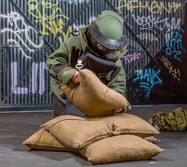 A soldier placing BlastSax around an IED at the Larkhill export showcase
